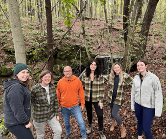 Arborwear Marketing team retreat. Team posing for the picture by a river in the woods.